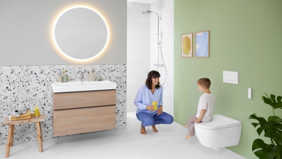 Vrouw en kind in een kleurrijke badkamer met Geberit Option spiegel en Geberit AquaClean Alba