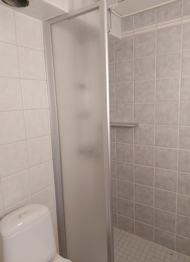 De foto vóór de renovatie met zicht op de douchecabine en de staande wc (© Meja Hynynen)